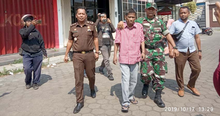 Tersangka pemalsuan akte tanah, Irwan Yudhiyanto (baju garis merah putih) saat diamankan oleh pihak Kejari dan TNI, di kantornya yang terletak di Jalan Pemuda Kaffa, Bangkalan. Kamis (17/10/2019)