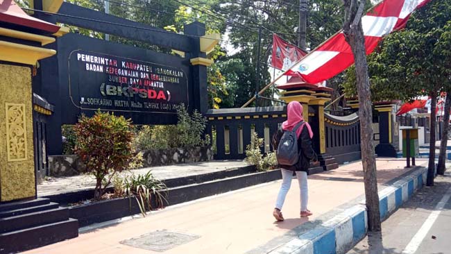 Seorang warga melintas di depan kantor BKPSDA Bangkalan,(19/8/2019)