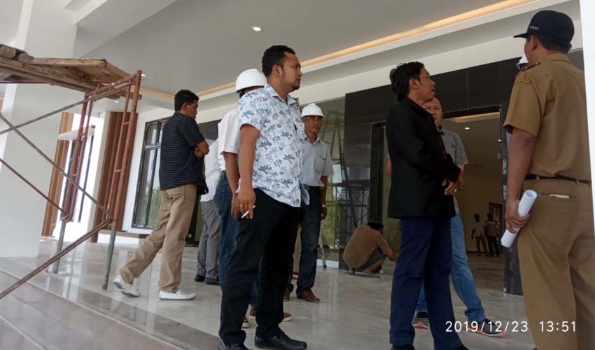 seorang pekerja sedang menyelesaikan pengerjaan gedung dewan