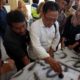Ketua Komisi D DPRD Bangkalan, Nur Hasan saat membubuhkan stempel diatas kain yang dibawa oleh massa