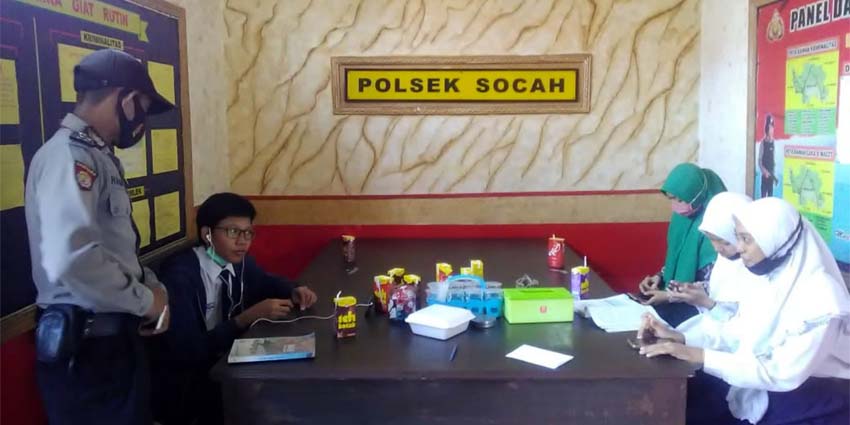 Petugas Polsek Socah saat mendampingi siswa belajar menggunakan wifi di Polsek Socah. (memo x/isn)